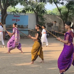 Girls in sarees practising Lathi Kathi in pairs at Bharde Highschool, Shevgaon