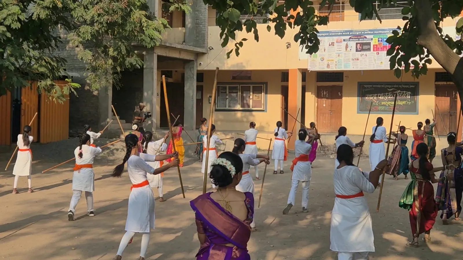 Rows of girls swinging lathis together during the Lathi Kathi camp in Shevgaon