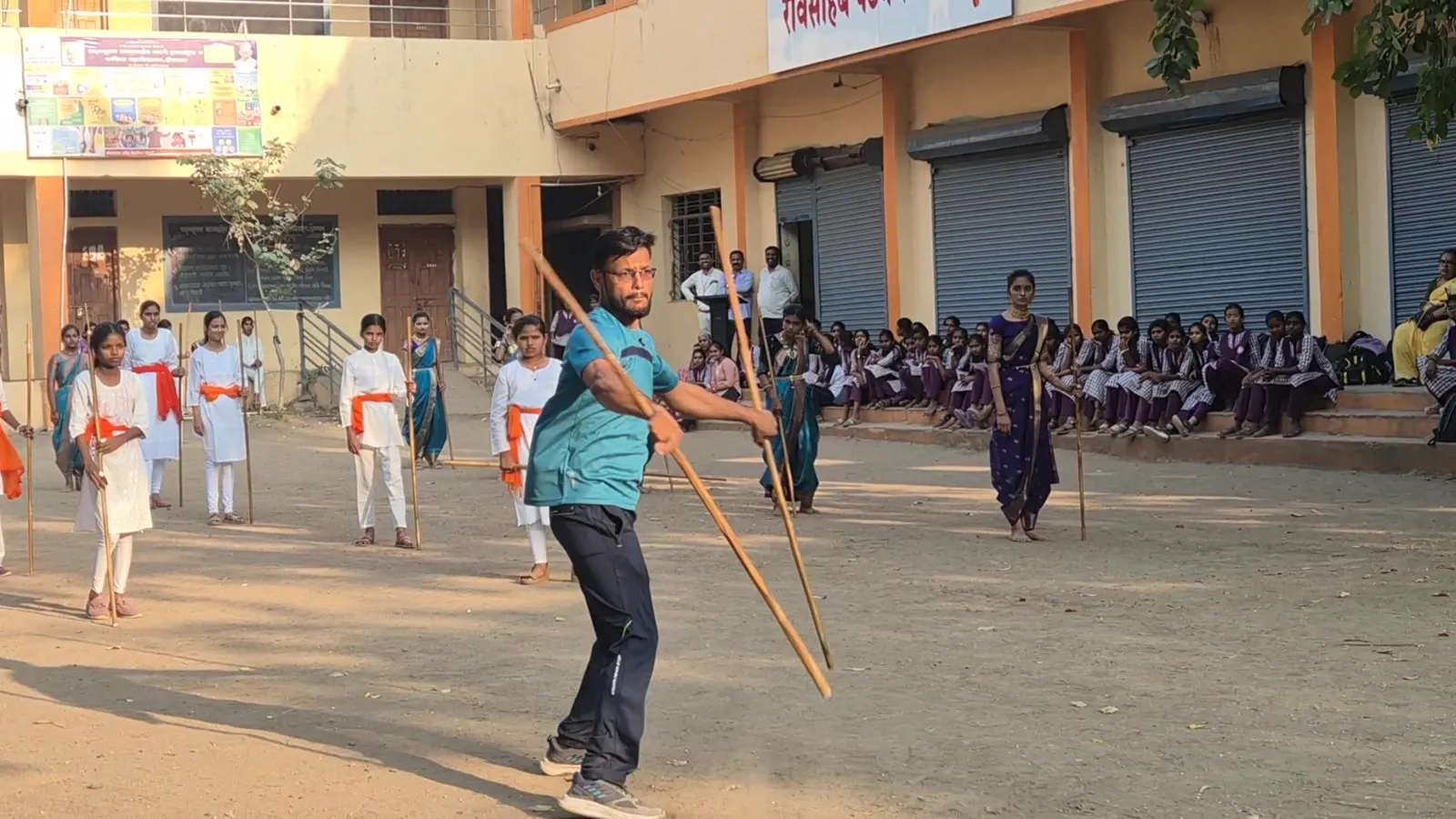 Instructor demonstrating a Lathi Kathi move to the girls in Shevgaon