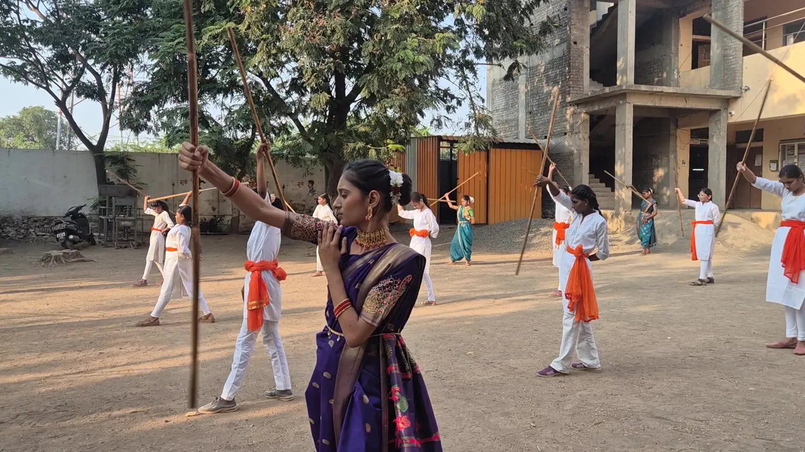 Girl in a saree with her lathi raised during the Lathi Kathi demonstration in Shevgaon