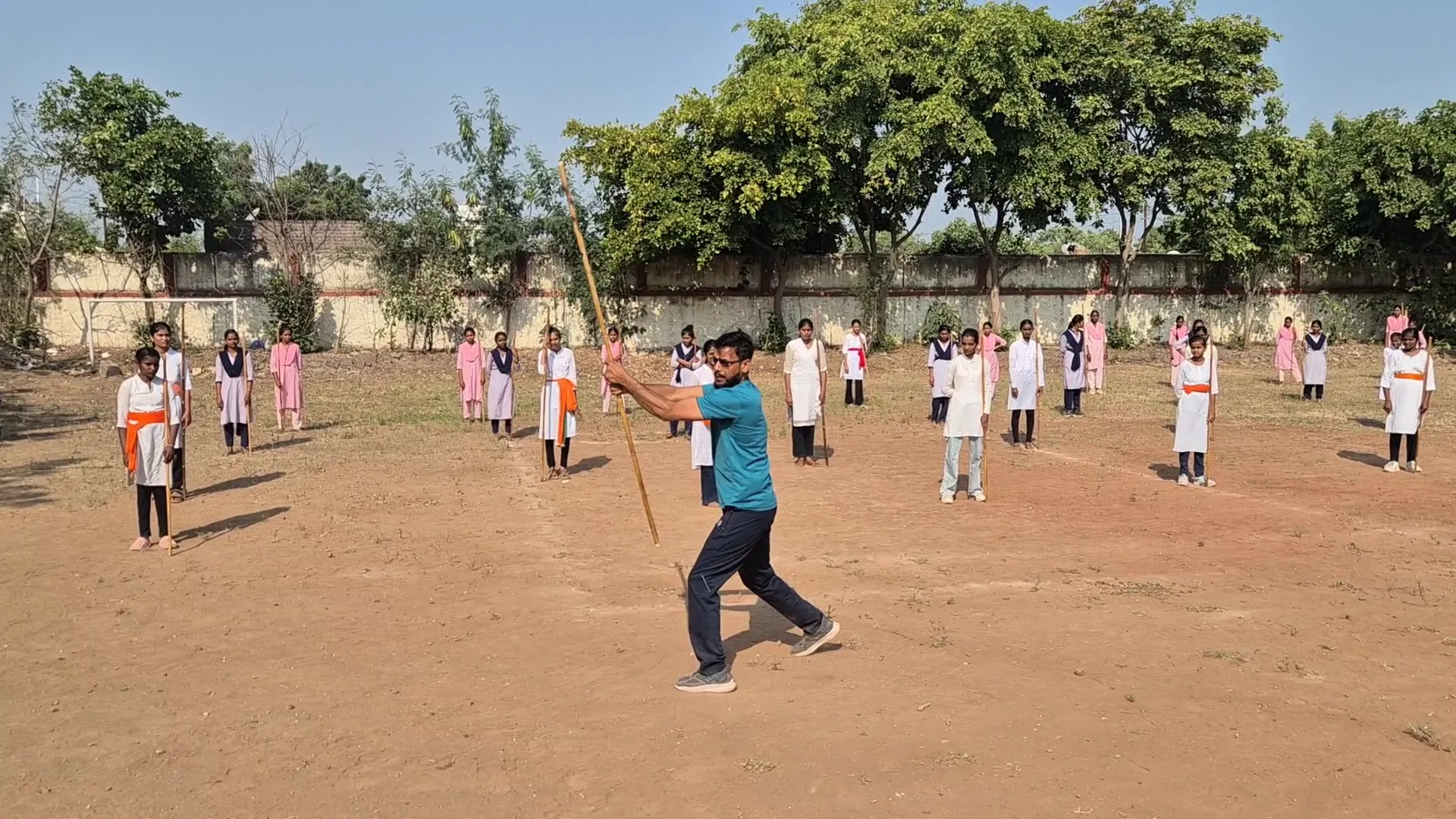 Instructor guiding rows of girls during Lathi Kathi training at New Arts, Commerce and Science College, Shevgaon